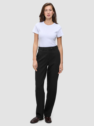 A woman wearing a white t-shirt and Women GO2 Pants Straight Black, which are high-waisted, straight-leg black trousers.