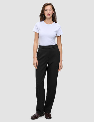 A woman wearing a white t-shirt and Women GO2 Pants Straight Black, which are high-waisted, straight-leg black trousers.