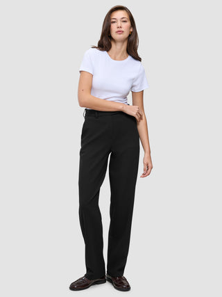 A woman wearing a white t-shirt, Women GO2 Pants Straight Black, and dark loafers.