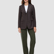 A person wearing a pinstripe blazer over a white t-shirt and Women GO2 Pants Straight Dusty Olive, styled with dark loafers.