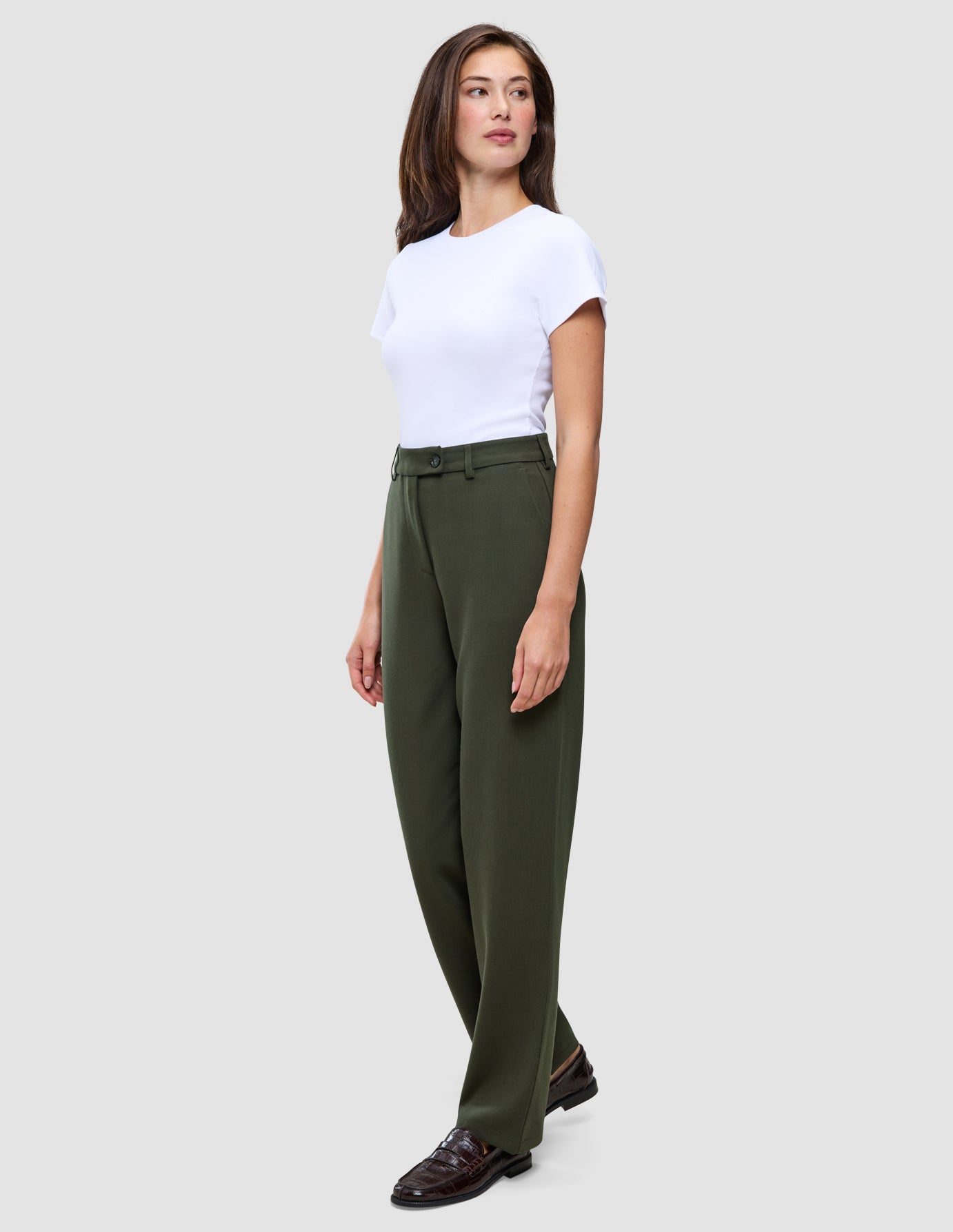 A person wearing a white t-shirt tucked into Women GO2 Pants Straight Dusty Olive and dark loafers.