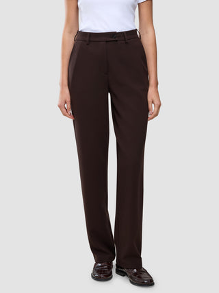 A person wearing Women GO2 Pants Straight Mocha high-waisted, dark brown straight-leg trousers and dark brown loafers.