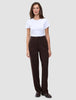 A woman wearing a white t-shirt and Women GO2 Pants Straight Mocha, featuring a high-waisted, straight-leg dark brown design.