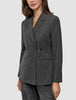 A woman wearing the Women Nara Blazer Fitted Black Check, a tailored, double-breasted blazer in a black and white checkered Scandinavian design.