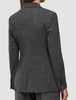 Back view of a person wearing a Women Nara Blazer Fitted Black Check, featuring a tailored black and white check design with notched lapels and buttoned cuffs.