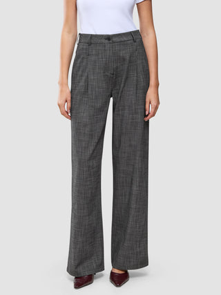 Women Nara Pants Wide Black Check in a dark grey check pattern, worn with a white top and dark pointed-toe shoes.