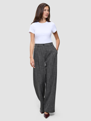 A woman wearing a white t-shirt and high-waisted, black and white Women Nara Pants Wide Black Check.