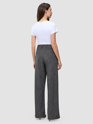 A person seen from behind wearing a white t-shirt and high-waisted Women Nara Pants Wide Black Check in a gray checkered print.