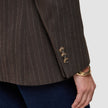 Close-up of a brown Women Serene Blazer Regular Walnut Herringbone featuring three buttons on the sleeve cuff, worn with dark denim jeans.