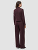 A person seen from behind wears the Women Serene Short Jacket Berry Pinstripe and matching wide-leg trousers in a Scandinavian design.