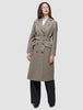 A model wears a Women Wool Coat Greige in a double-breasted Scandinavian design with a knee-length cut and matching tie belt over a white shirt and black trousers.