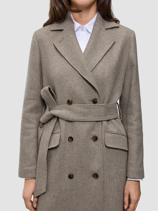 Women Wool Coat Greige in a double-breasted Scandinavian design, featuring a tie waist and flap pockets worn over a white collared shirt.