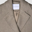 Close-up of a Women Wool Coat Greige, featuring a double-breasted design with wide lapels and a brand label at the neckline.