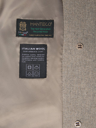 Interior view of the Women Wool Coat Greige, a light gray, double-breasted wool coat featuring two labels detailing Italian recycled wool and performance features, with two buttons visible on the right.