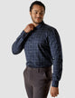 Model from the front wearing a Classic Shirt Dark Sky the shirt is solid navy with a wide checked pattern