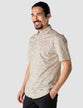 Model from the front wearing a Classic Short-Sleeved Shirt Clover the shirt is White with a solid beige floral pattern