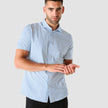 Model from the front wearing a Classic Short-Sleeved Twill Shirt Light Blue Stripes the shirt is White a subtle twill pattern and light blue stripes 