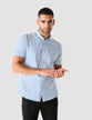 Model from the front wearing a Classic Short-Sleeved Twill Shirt Light Blue Stripes the shirt is White a subtle twill pattern and light blue stripes 