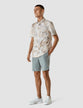 Model in full body wearing a Classic Short-Sleeved Shirt Stone a light shirt with a slolid marbled pattern