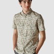 Model from the front wearing a Classic Short-Sleeved Shirt Dried Leaves the shirt is White with a near solid pattern of green leaves