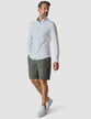 Model in full body wearing Essential Shorts urban green shorts with a white shirt