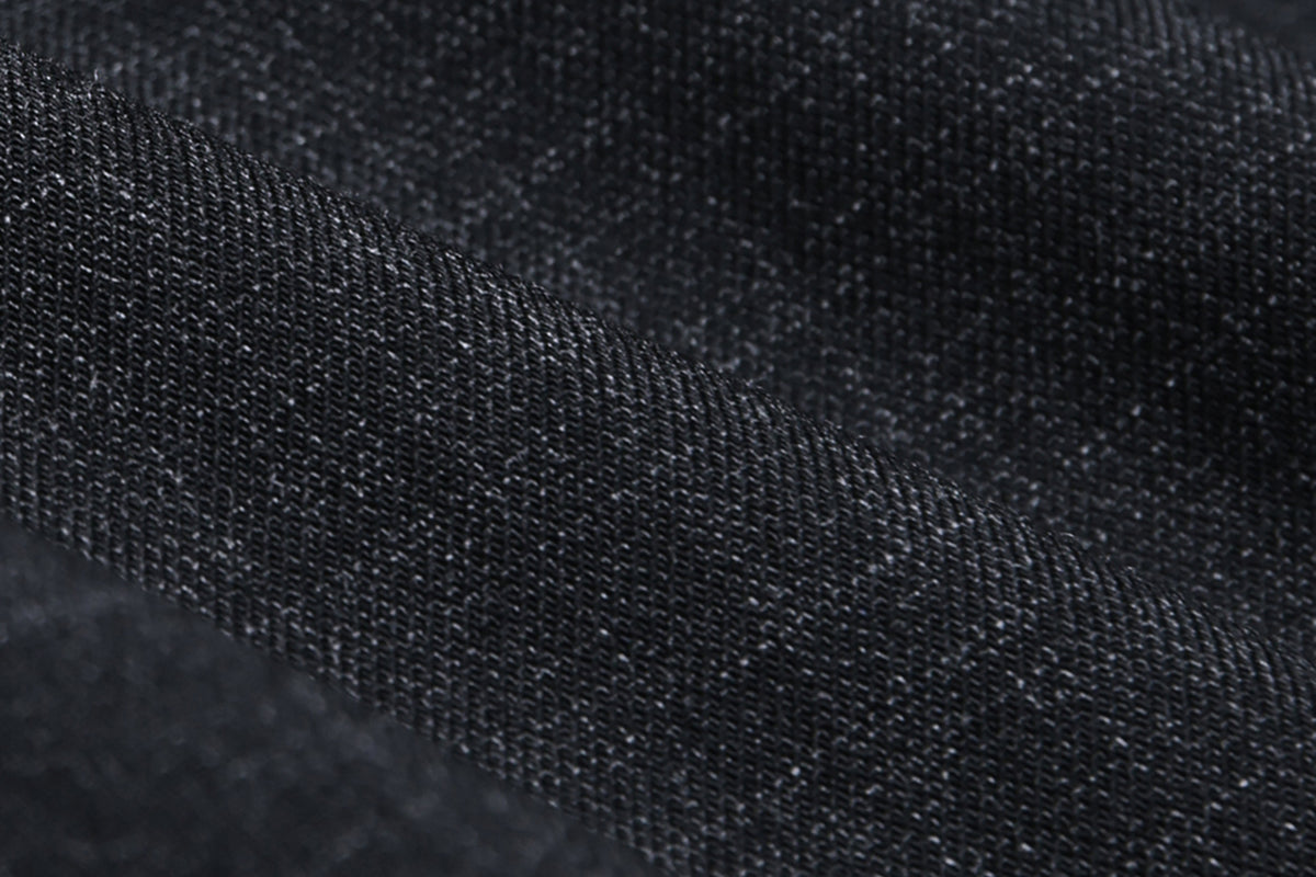 Close-up of black denim fabric with visible texture.