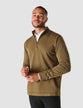 Model seen from the front wearing a Dark Olive half zip in fitted knit with a white shirt underneath
