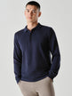 Model seen from the front wearing a navy Poloshirt in fitted knit