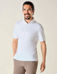 Model from the front wearing a White polo with brown pants