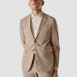 Model from the front wearing a Sand Grain Blazer with a shirt and matching suit pants