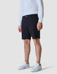 Model seen from the front wearing Essential Shorts Midnight Blue with a white shirt tucked in