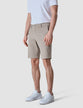 Model seen from the front wearing Classic Shorts Sand/Beige with a white t-shirt tucked in