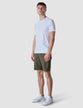 Model in full body wearing Classic Shorts urban green shorts with a white t-shirt