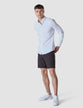 Model in full body wearing Essential Shorts dark shadow/Dark grey shorts with a white shirt