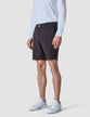 Model seen from the front wearing essential Shorts dark shadow/Dark grey shorts with a white shirt