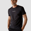 Model wearing black t-shirt seen from the front the t-shirt has the company logo across the chest
