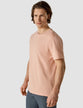 Model wearing a coral t-shirt seen from the front