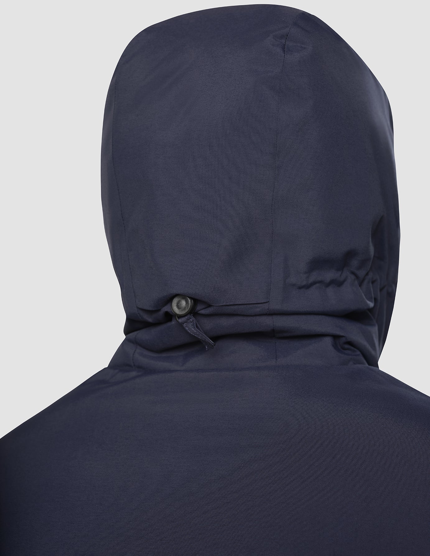 Back view of a Utility Jacket Dark Navy, a hooded jacket in dark navy featuring an adjustable cinch cord on the hood and recycled polyester construction.