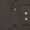 Close-up of the dark brown Atelier Overshirt in a heavyweight textured fabric, featuring two front buttons and two matching buttons on the sleeve cuff.