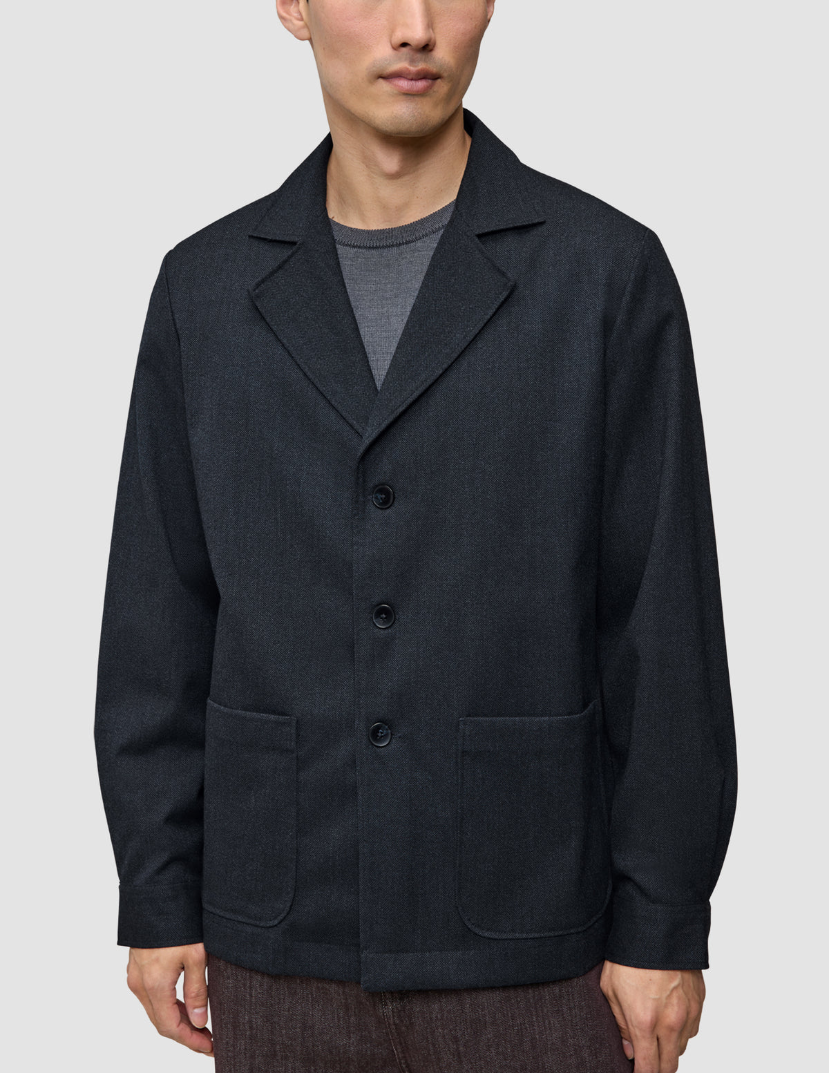 A person wears the Atelier Overshirt Dark Navy, a dark navy overshirt blazer in a heavyweight textured fabric featuring a notched collar and two patch pockets.