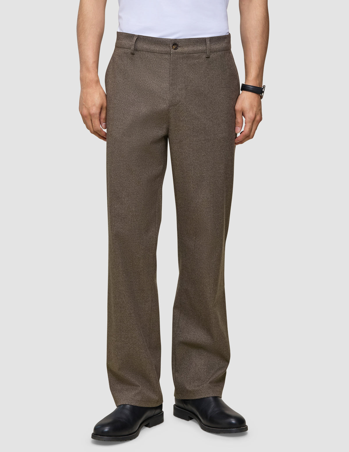 A person wearing dark beige Atelier Pants Relaxed in heavyweight broken twill and black leather dress shoes.