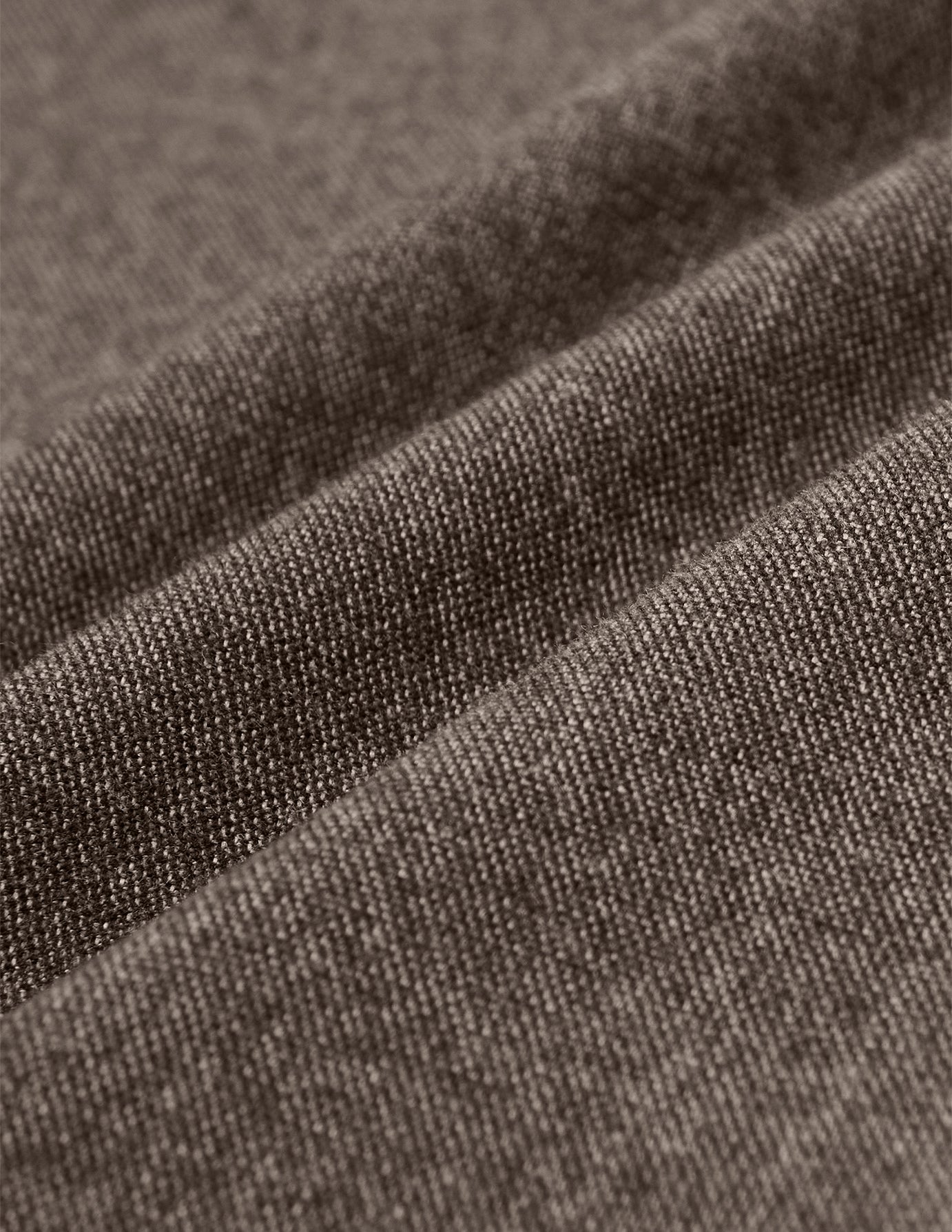 Close-up of the Atelier Pants Relaxed Dark Beige, showing folded heavyweight fabric in a dark beige broken twill with a visible woven texture.