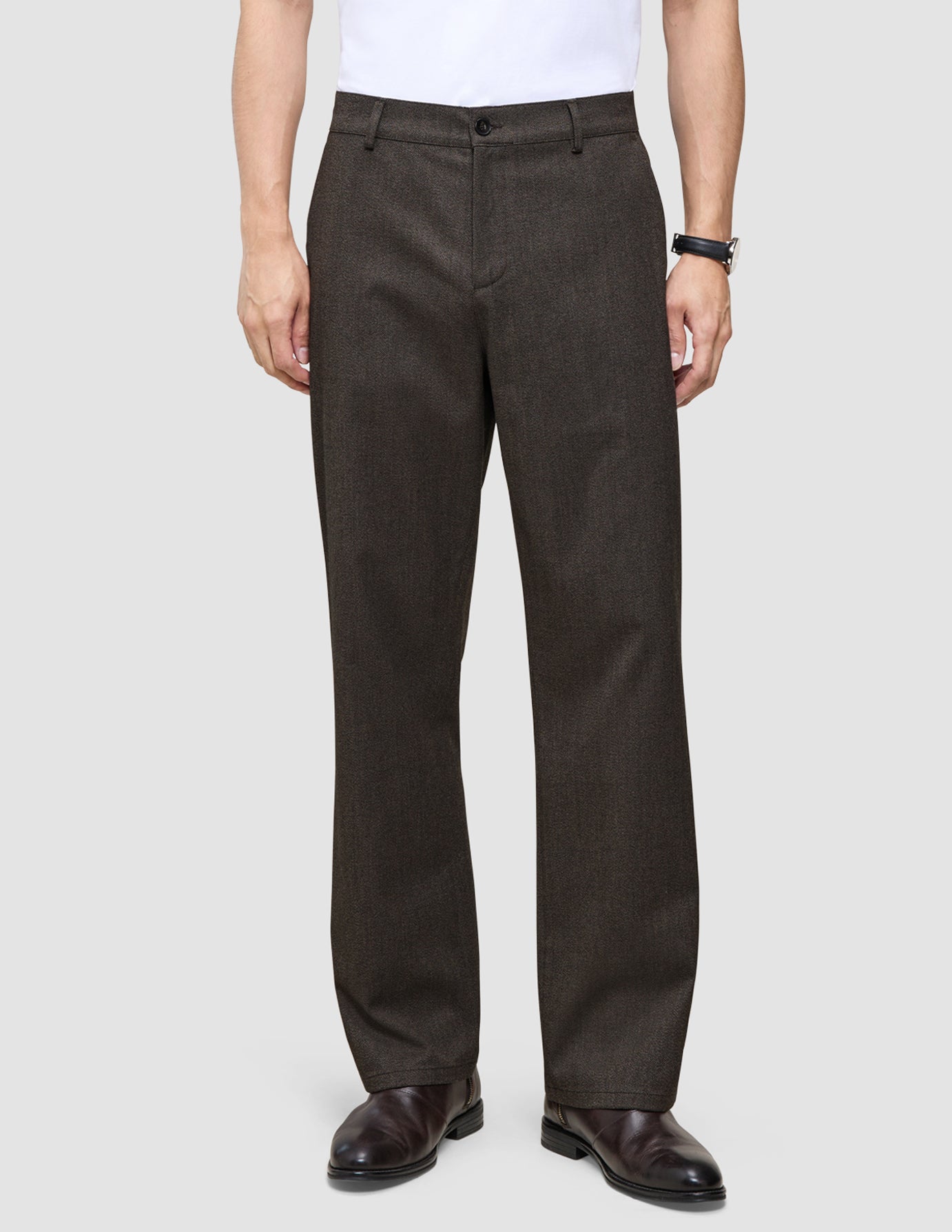 A person wearing Atelier Pants Relaxed Dark Brown in heavyweight broken twill, paired with a white shirt and dark leather dress shoes.