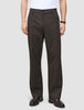 A person wearing Atelier Pants Relaxed Dark Brown in heavyweight broken twill, paired with a white shirt and dark leather dress shoes.
