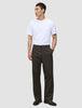 A person wearing a white t-shirt and Atelier Pants Relaxed Dark Brown in heavyweight broken twill, paired with dark leather shoes.