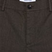 Close-up of dark brown Atelier Pants Relaxed Dark Brown in heavyweight broken twill, featuring a button closure and a brand label at the waistband.