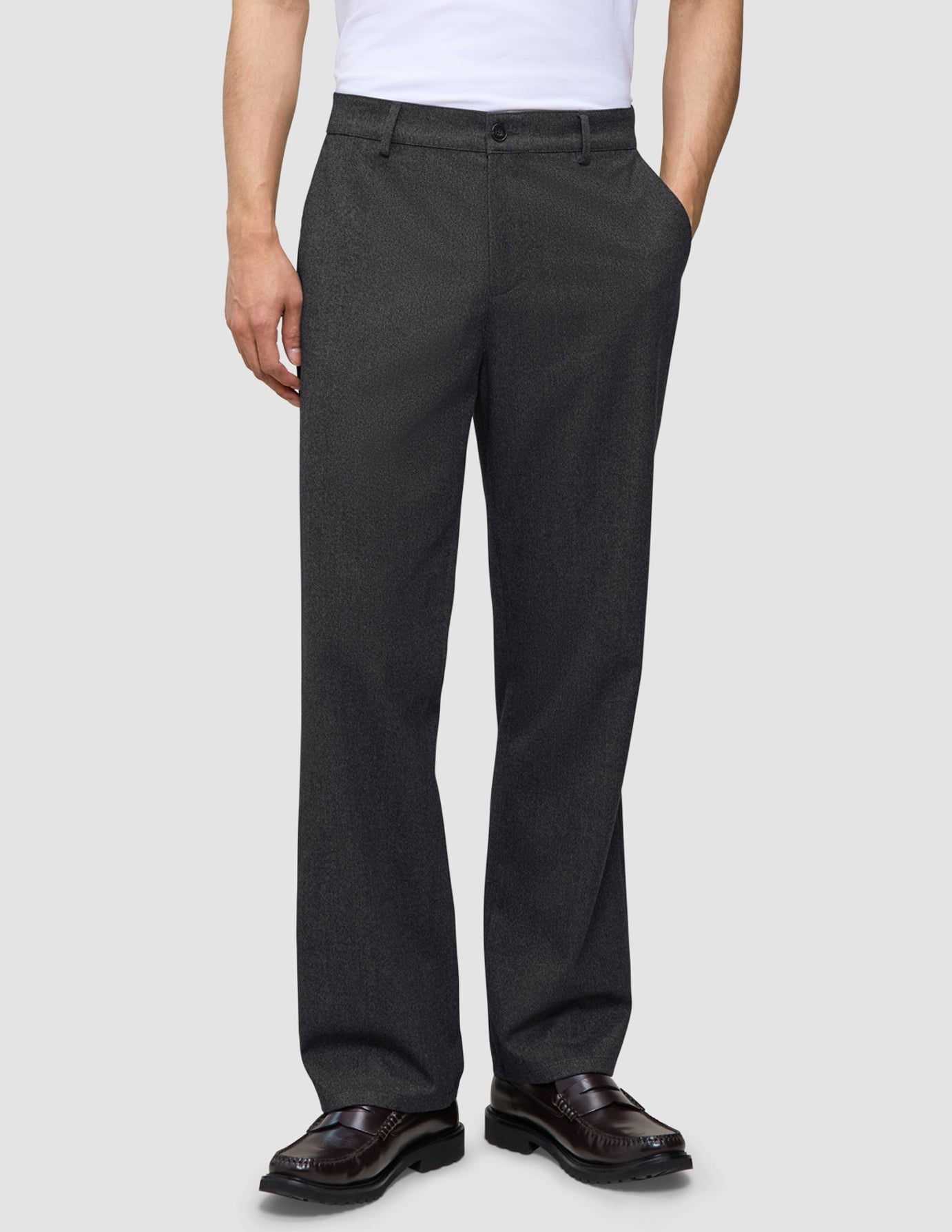 A person wearing dark grey Atelier Pants Relaxed in heavyweight broken twill paired with dark leather loafers.