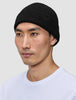 A person wearing a black, rib-knit merino wool Beanie Black.