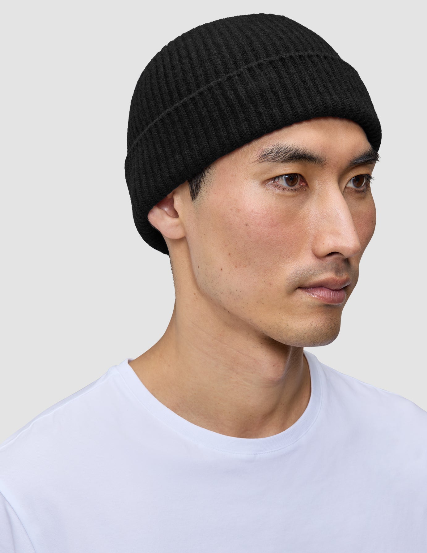 A person wearing a black rib knit Beanie Black.