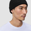 A person wearing a black rib knit Beanie Black.